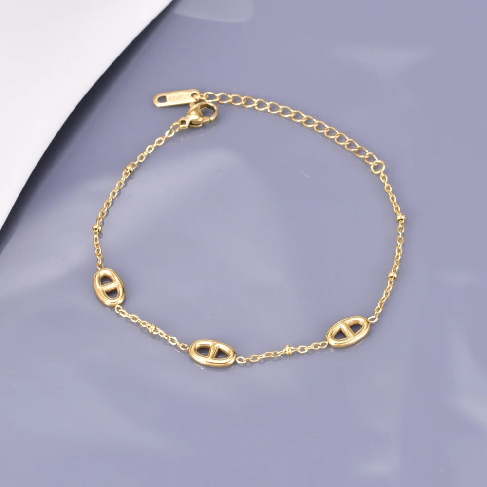 Gold-Plated Stainless Steel Bracelet – Oval Charm Link Chain with Adjustable Clasp & Muted Gray Backdrop